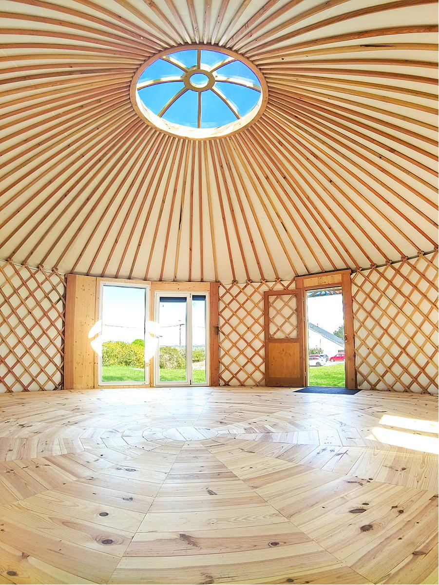 Intérieur de la yourte vu vers le dôme et son puits de lumière
